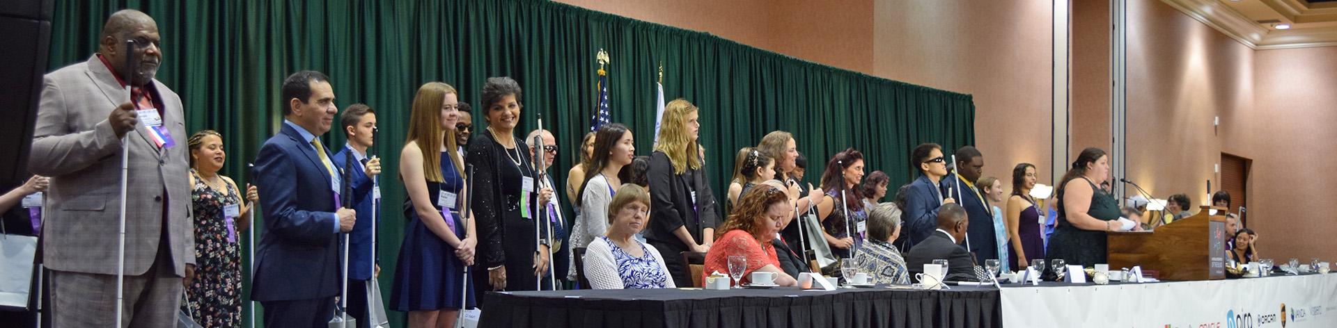 NFB scholarship winners stand on stage to receive their awards.